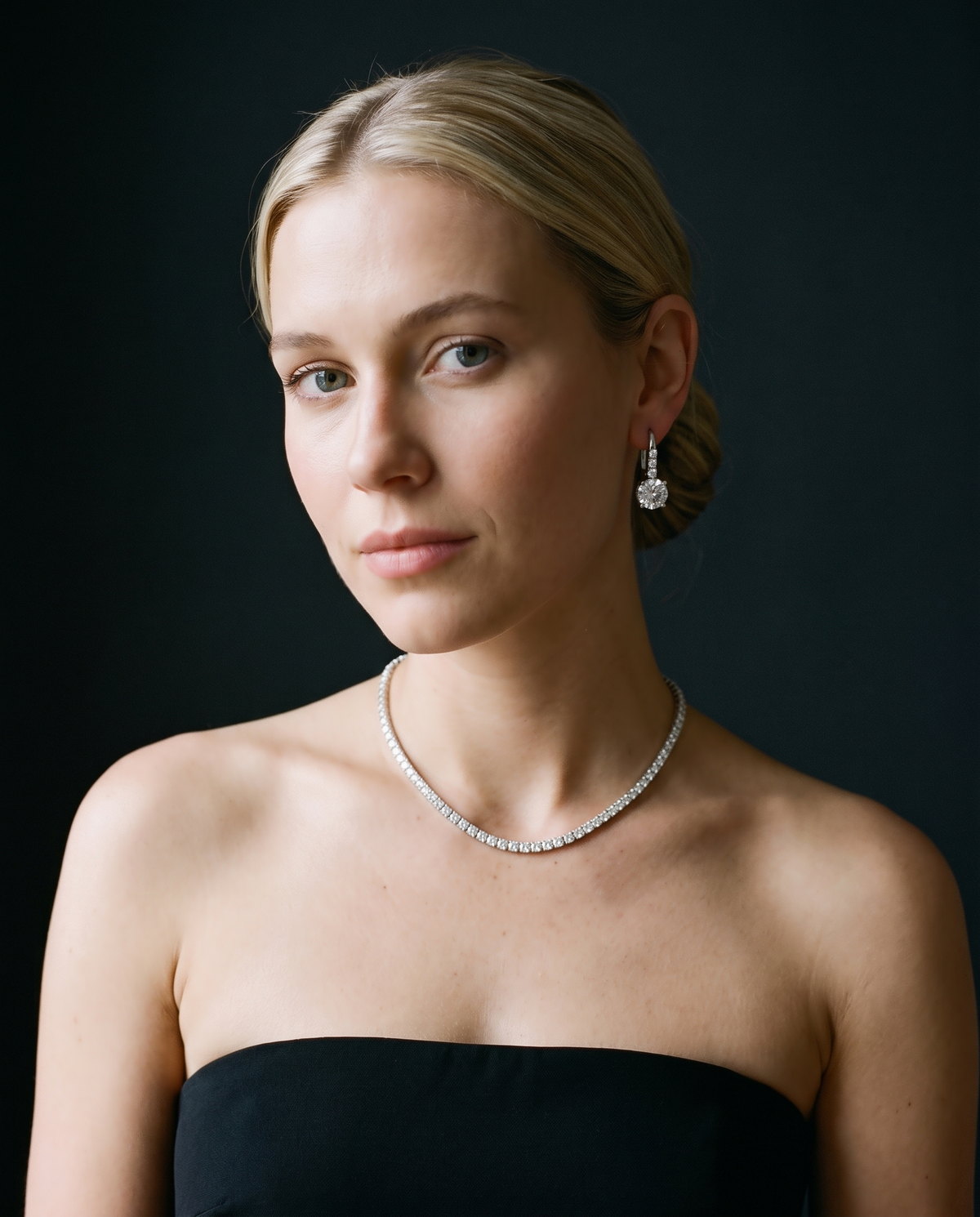 Modelo de vestido preto com riviera e brincos de diamante